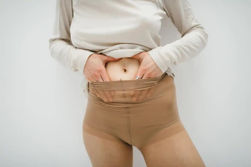 Person holding their gut while wearing constricting stockings