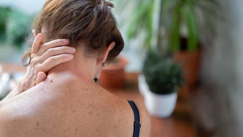 person rubbing their neck in pain