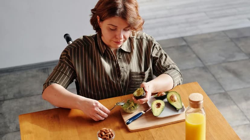 Person in wheelchair slicing avocado at a table
