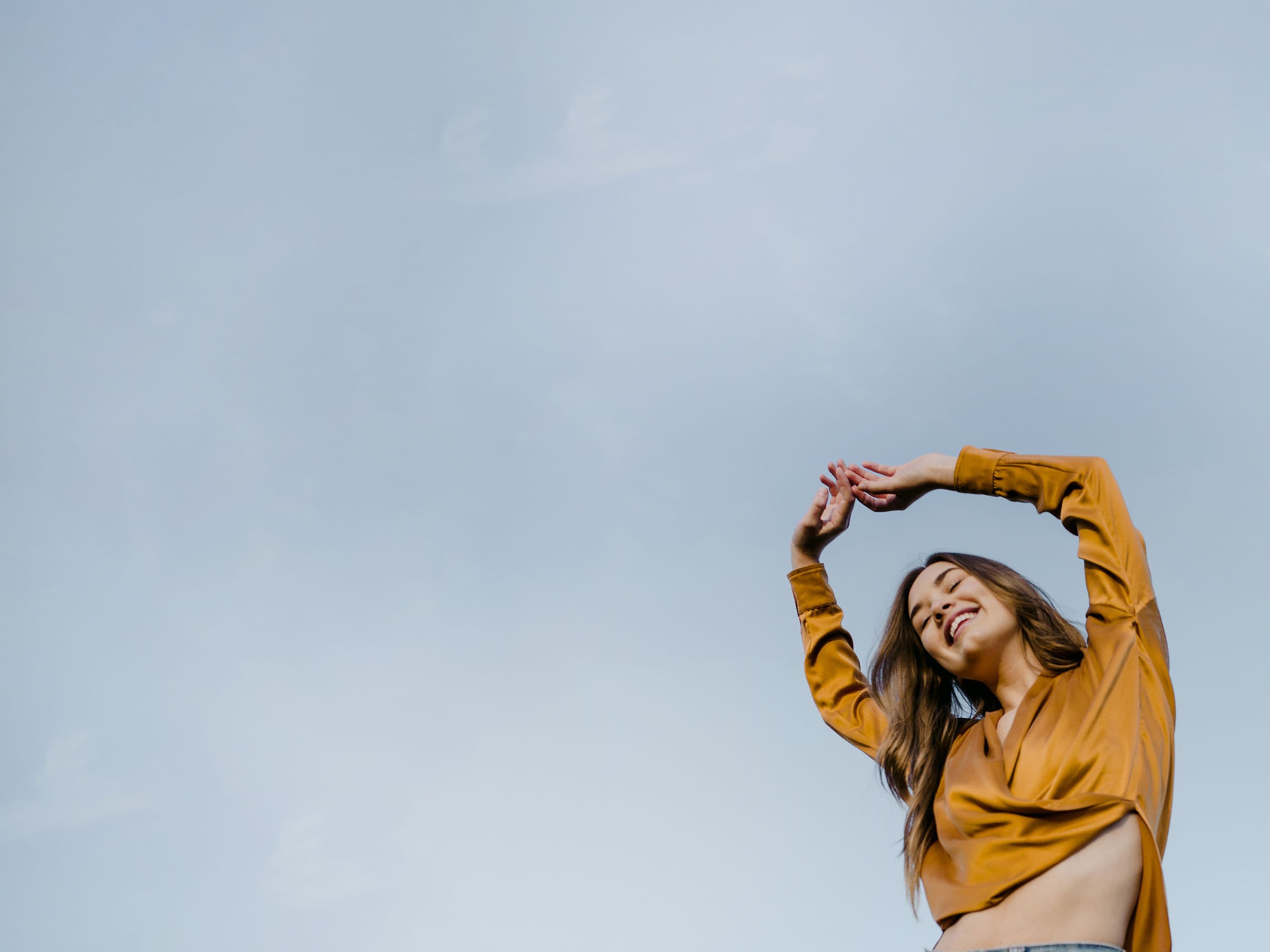 Happy woman stretching arms in the sky, feeling better